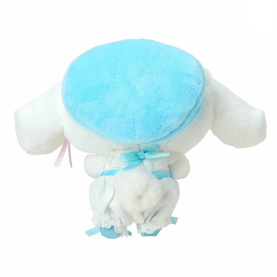 Plush toy resembling a dog with a blue hat on a white background